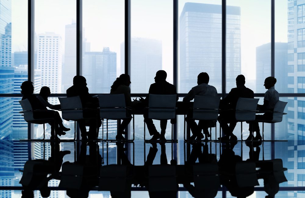 Executives in a boardroom against a city skyline