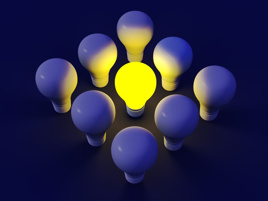 A single lit lightbulb among unlit ones
